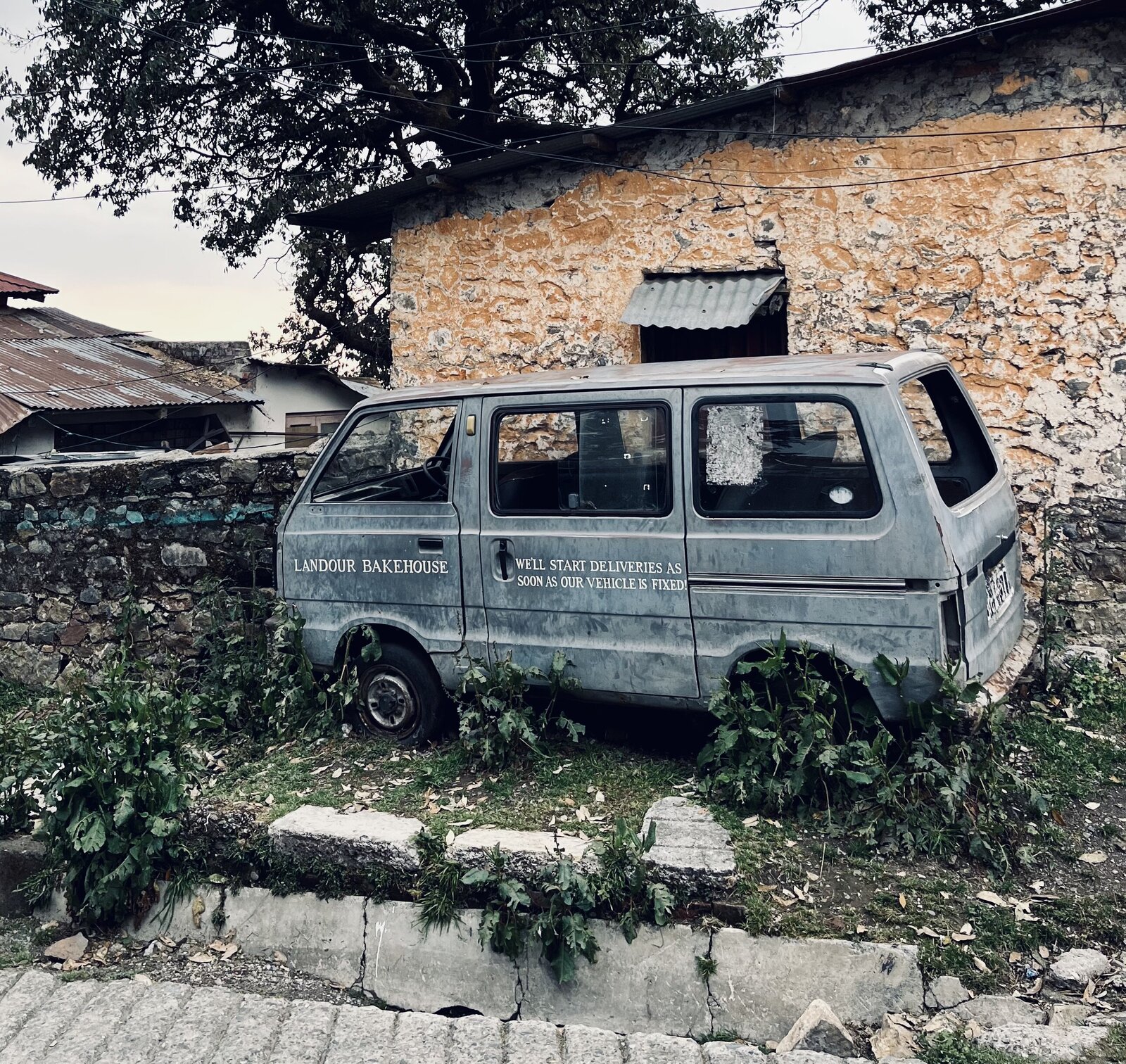Broken down car with text on the side 'We'll start delivery as soon as our vehicles are fixed'